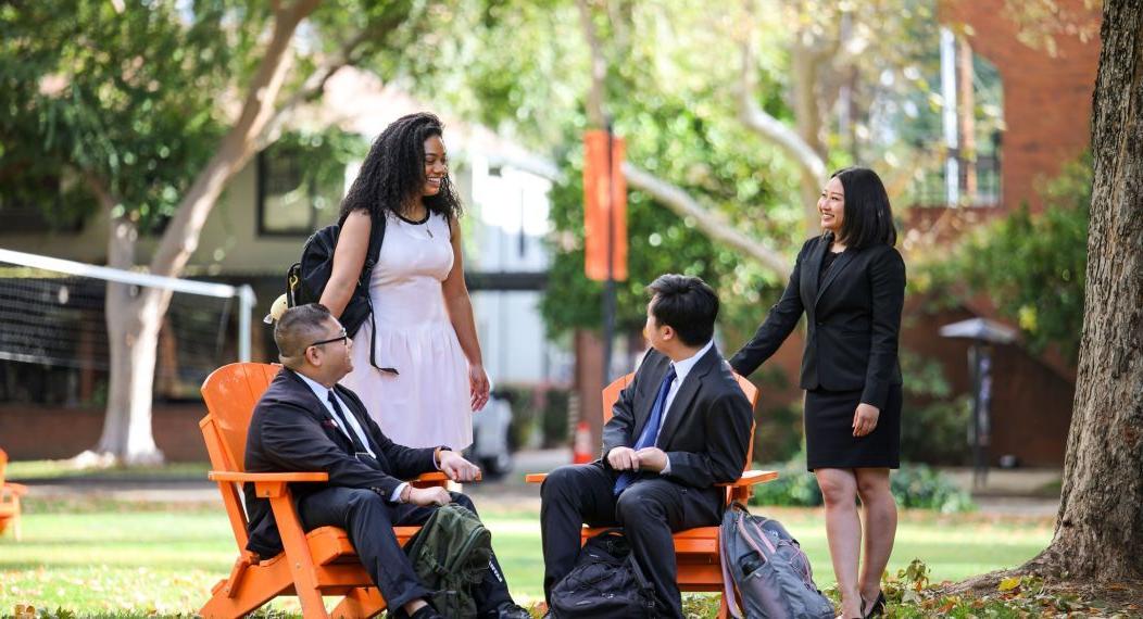 Four students sitting at McGeorge School of Law campus